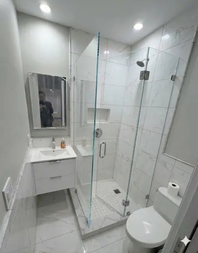 Illustration of a hinged shower door and fixed panel in a tiled bathroom