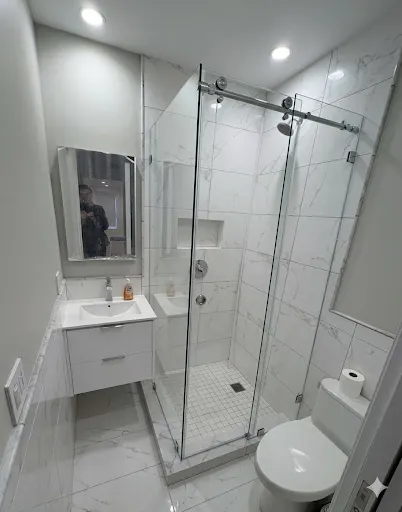 Illustration of a sliding shower door with a top rail in a tiled bathroom