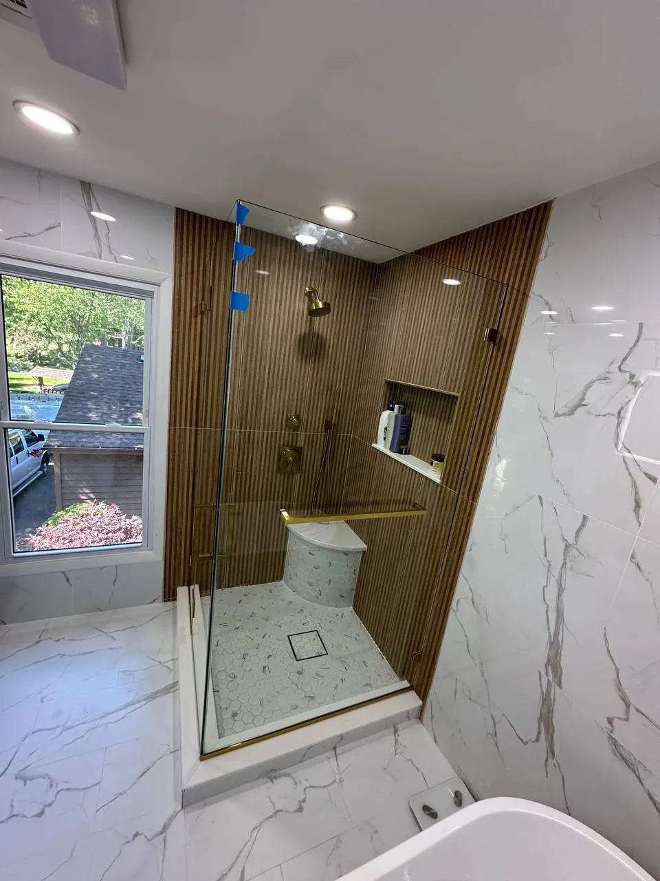 Clear shower glass with brass hardware in the Edison, New Jersey project
