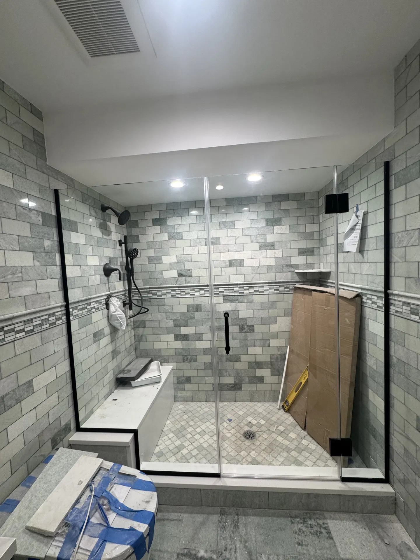 Dark glass shower door in a tiled bathroom